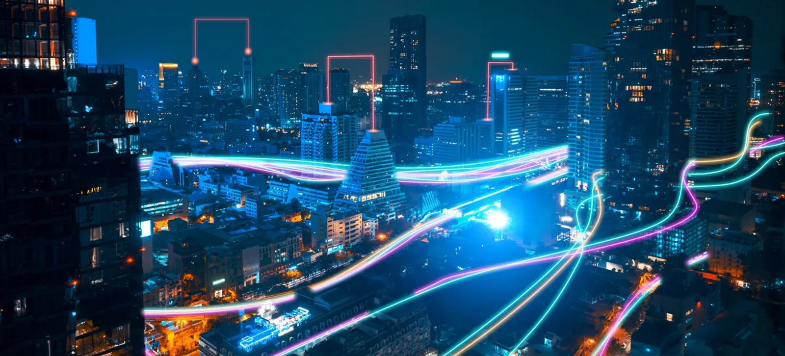 Ciudad de noche con haces de luz que representan la red de fibra óptica de Furukawa
