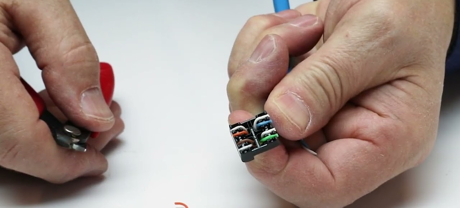Manos de un instalador terminando un conector Leviton de cobre sobre una mesa de trabajo