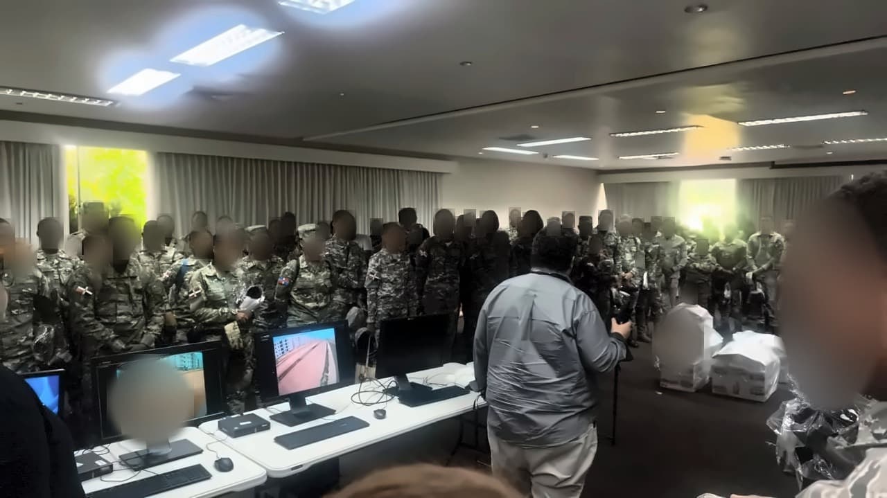 Capacitación del personal militar de seguridad en la sala del centro de control, frente a los puestos de monitoreo de las cámaras