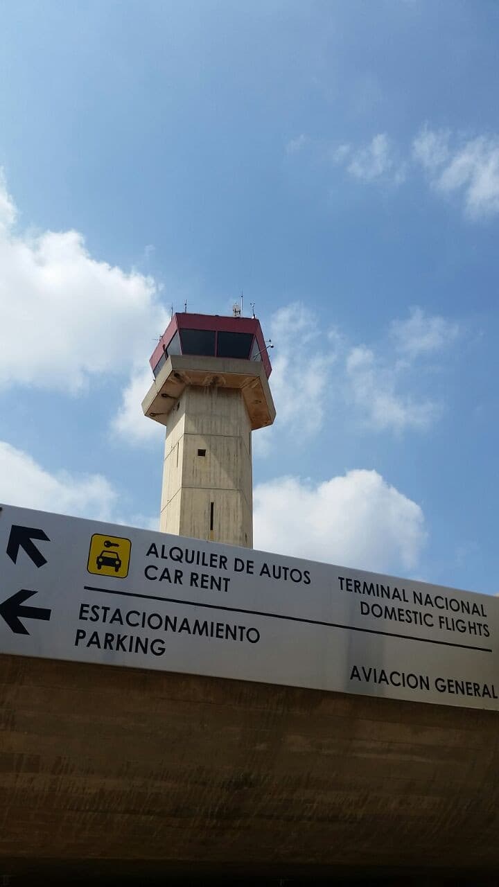 Torre de control del Aeropuerto Internacional La Chinita con señalización de acceso en primer plano