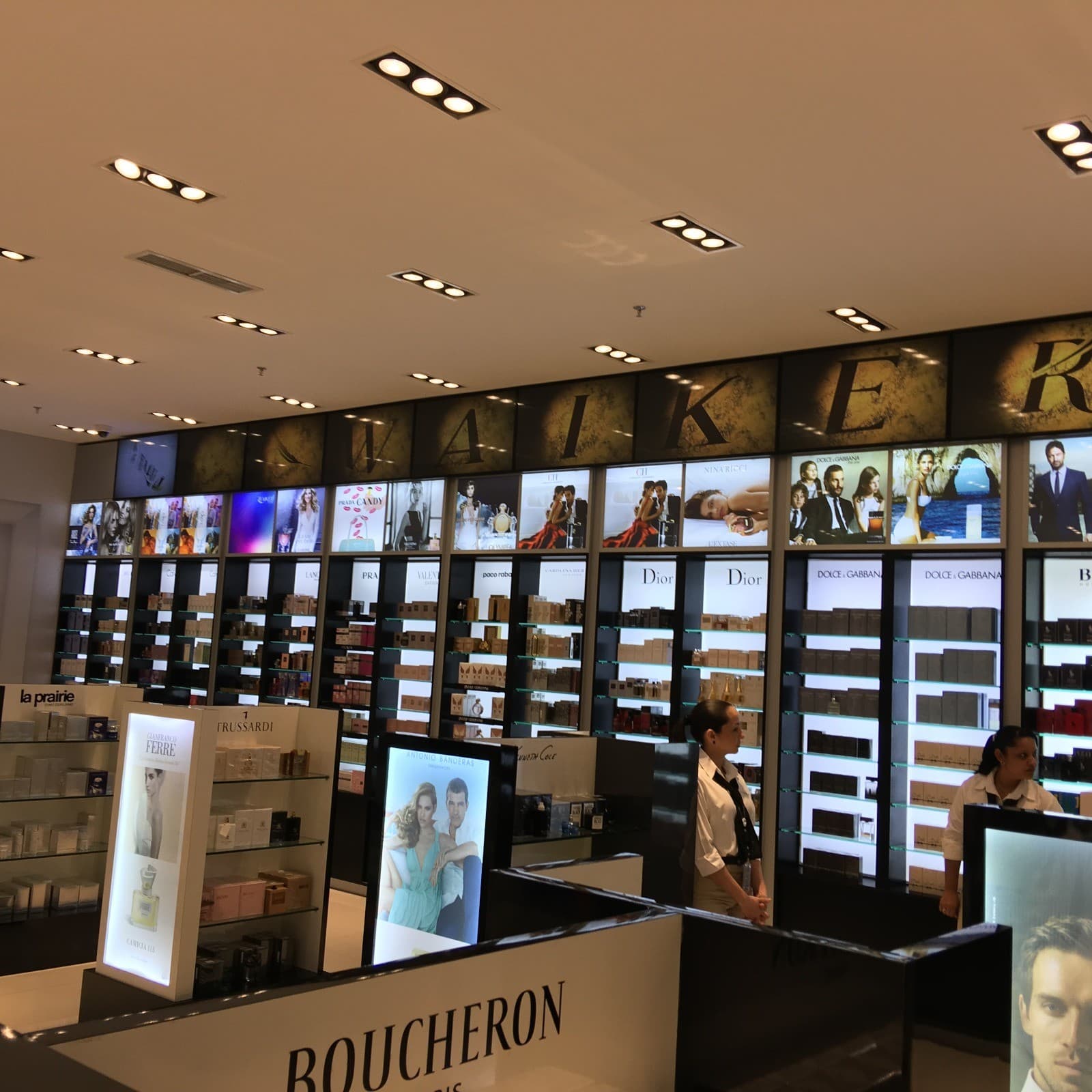 Sala de perfumería del duty free con vitrinas retroiluminadas y rótulo Waikerí