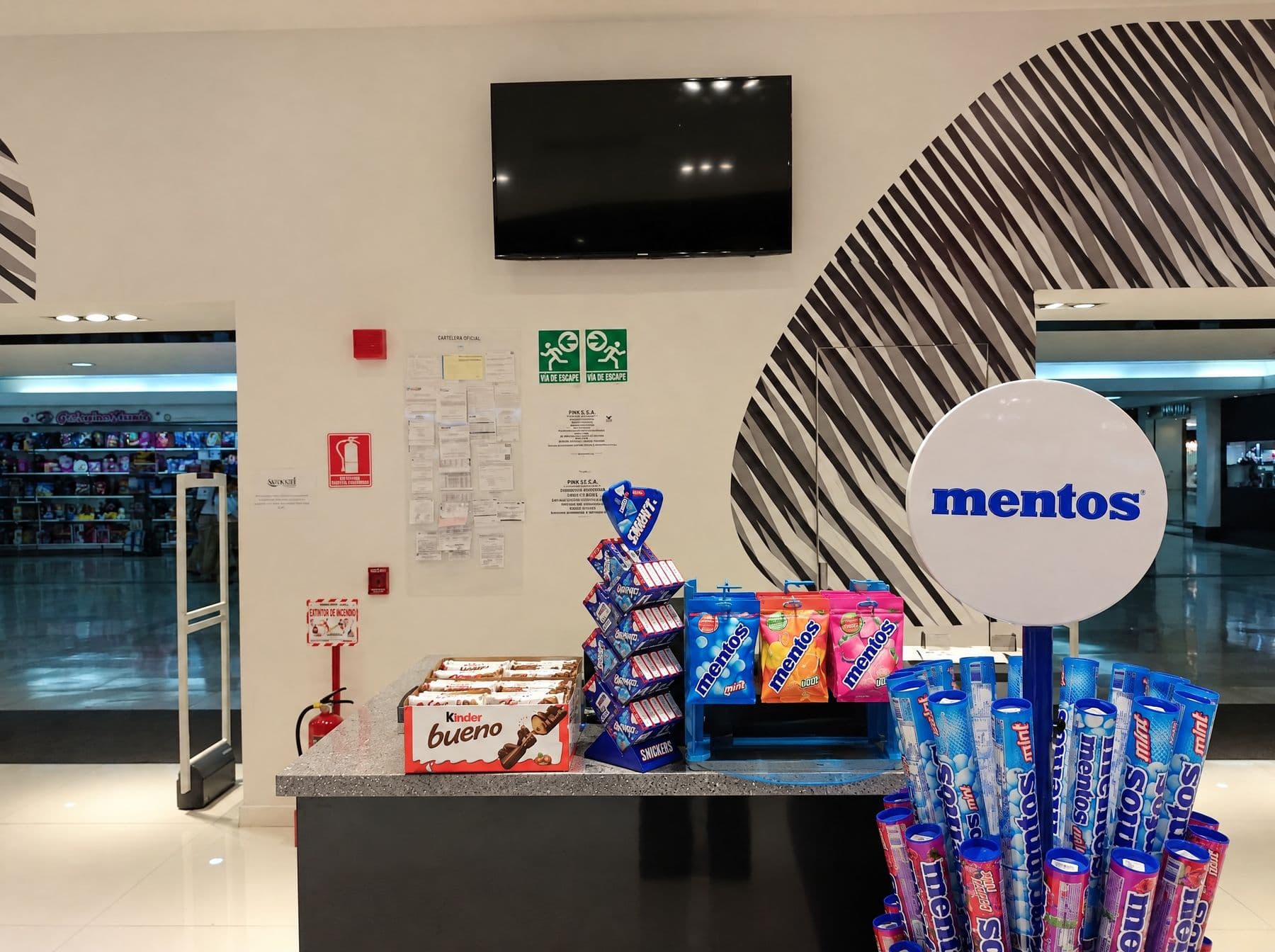 Zona de caja del duty free con pantalla en pared y antena antihurto en el acceso